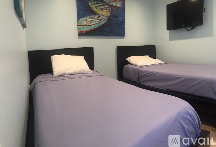 Two beds with purple bedspreads in a room.