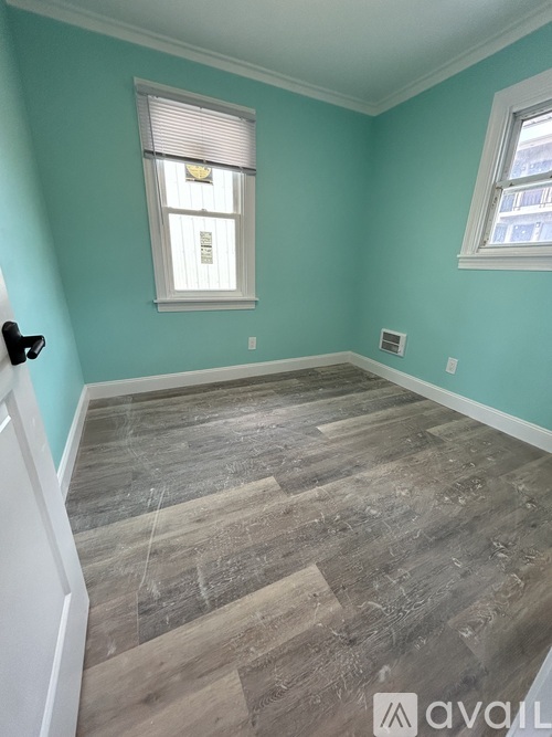 A room with light blue walls and wooden flooring.