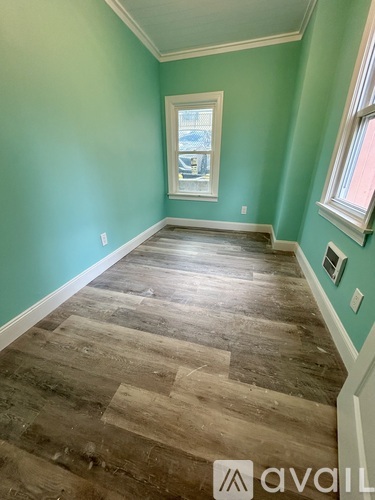 A room with wooden flooring and a window.