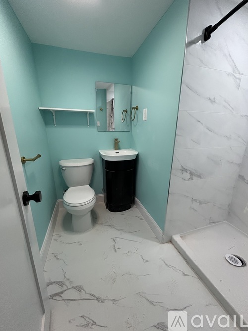 A bathroom with a toilet, sink, and a mirror.