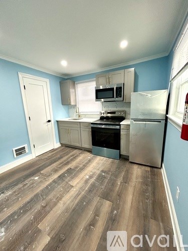 A kitchen with a stove top oven and a refrigerator.
