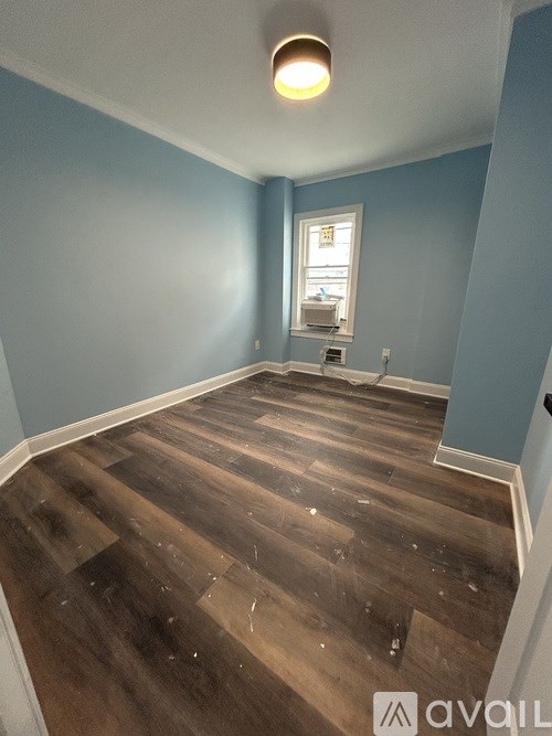 A room with wooden flooring and a window.
