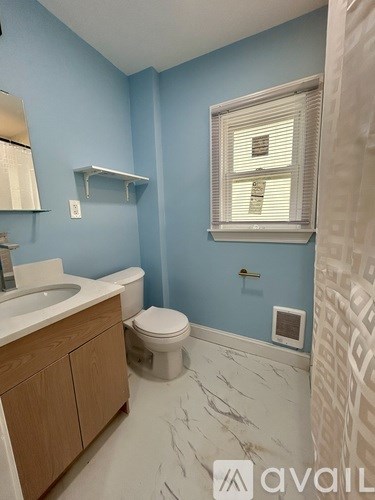 A bathroom with blue walls and a marble floor.
