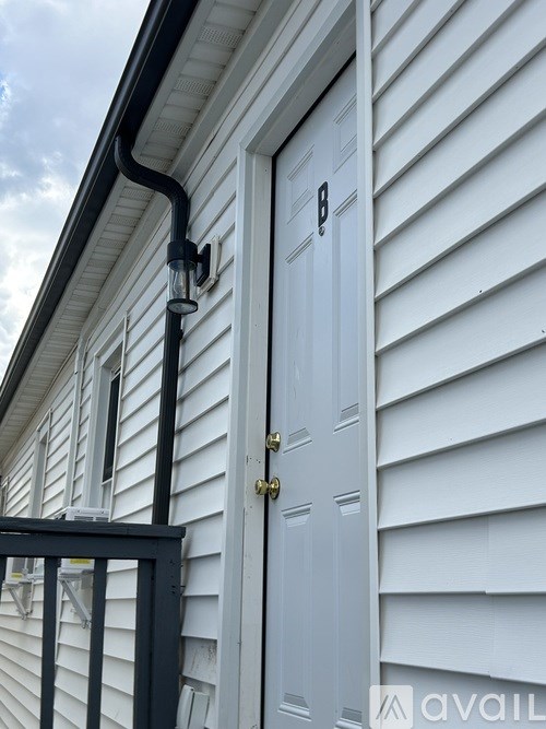 A white door with a black handle and a black railing.