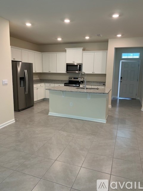 A kitchen with white cabinets and a tiled floor.