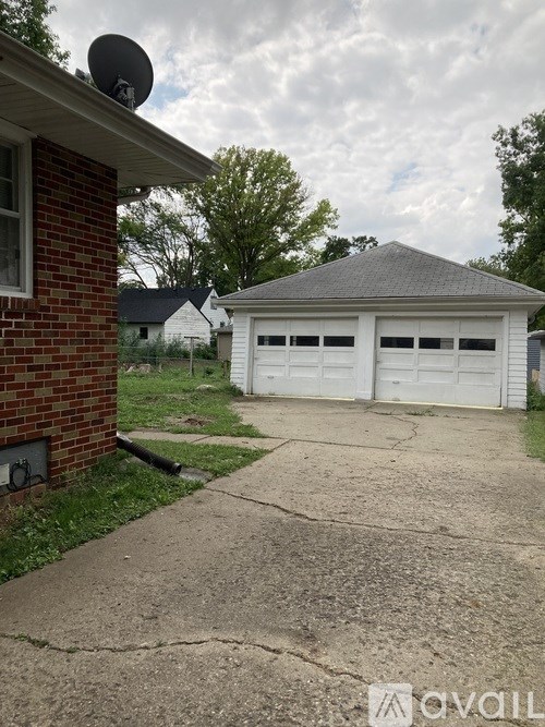 A house with a garage and a satellite dish on the roof.