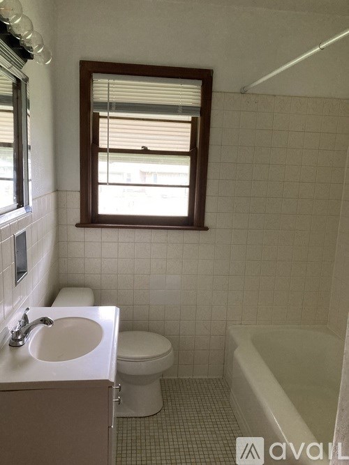A bathroom with a toilet, sink, and bathtub.