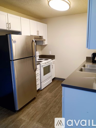 A kitchen with a stainless steel refrigerator and a stove top oven.