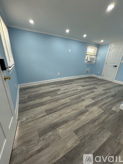 A room with wooden flooring and a white door.