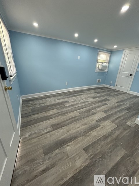 A room with wooden flooring and a white door.