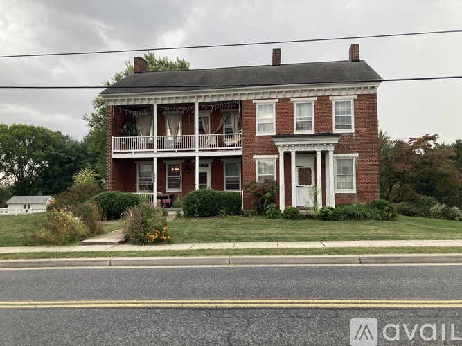 A two-story brick house with a porch and a white door.