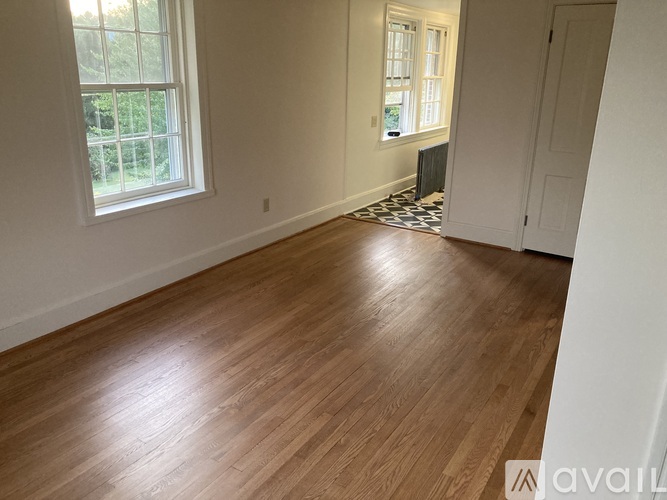 A room with wooden flooring and a window.
