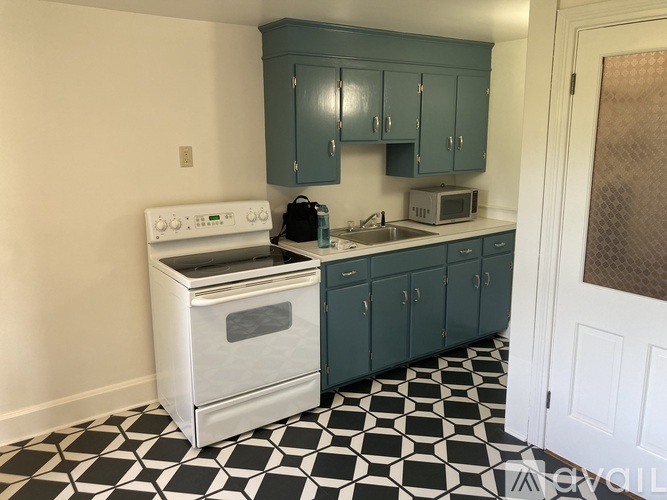 A kitchen with a black and white checkered floor.