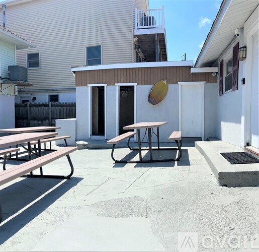 A patio with a table and chairs is in front of a house.