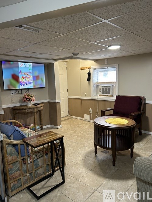 A room with a television, a chair, and a table.