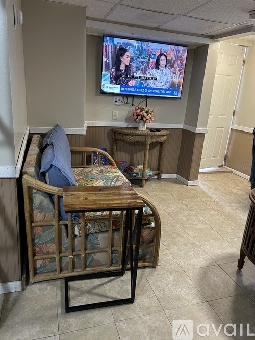 A room with a wooden chair and a television displaying a video call.