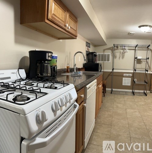 A kitchen with a white gas stove and wooden cabinets.