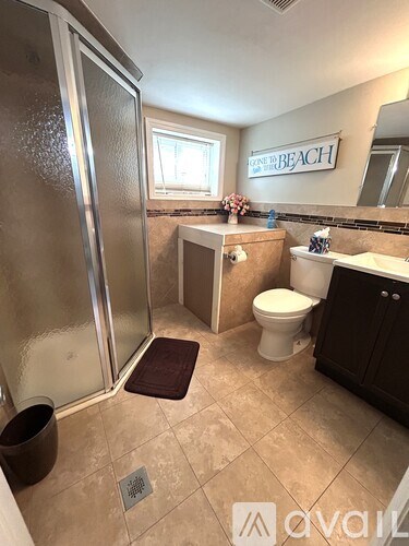 A bathroom with a toilet, sink, and shower.