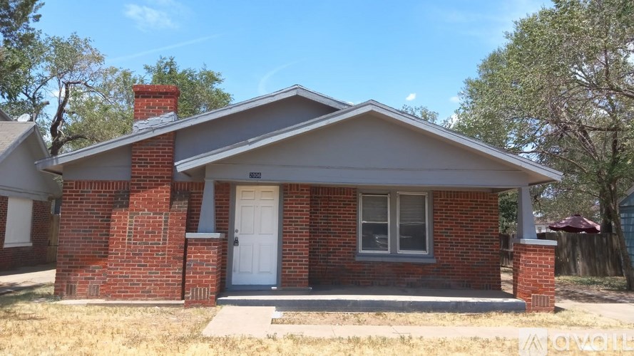 A small house with a white door and a brick chimney.