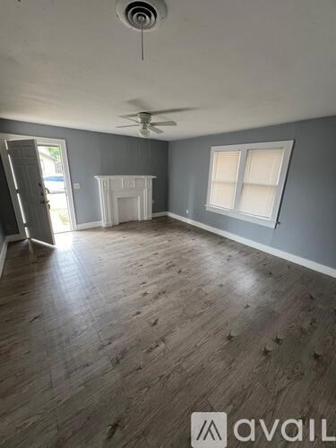 A room with wooden flooring and a ceiling fan.