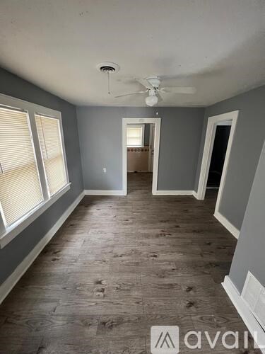 A room with wooden flooring and a ceiling fan.