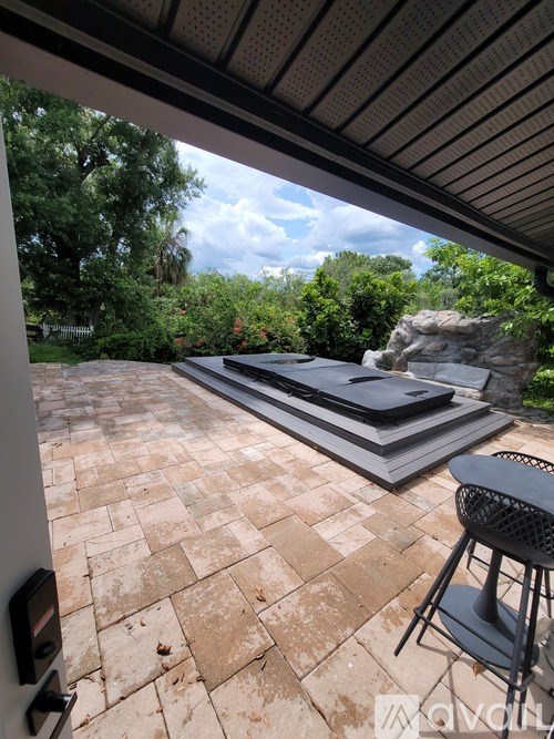 A patio with a table and chairs and a grill.
