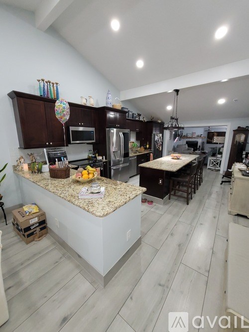 A kitchen with a granite countertop and stainless steel appliances.