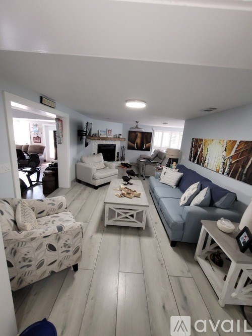 A living room with a white couch and a grey coffee table.