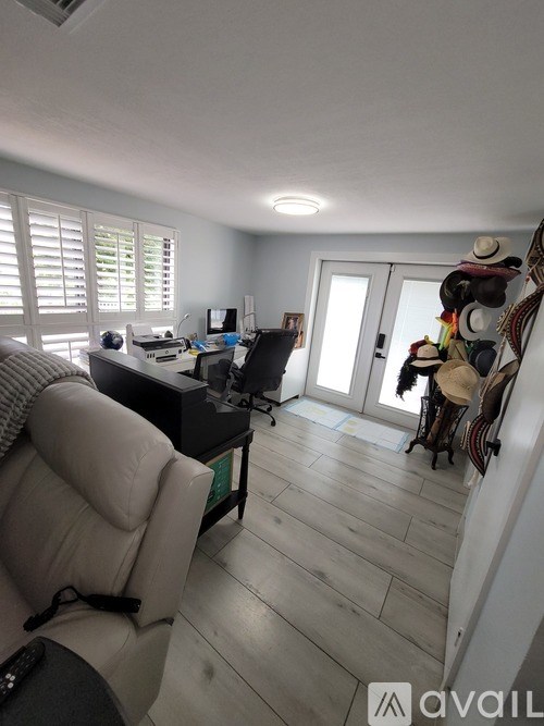 A room with a desk, chair, and a wall with a window.