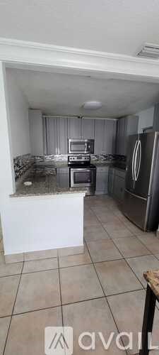 A kitchen with a refrigerator, oven, and microwave.