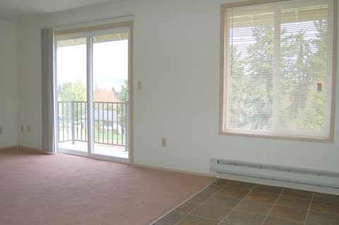 A room with a sliding glass door and a window with blinds.