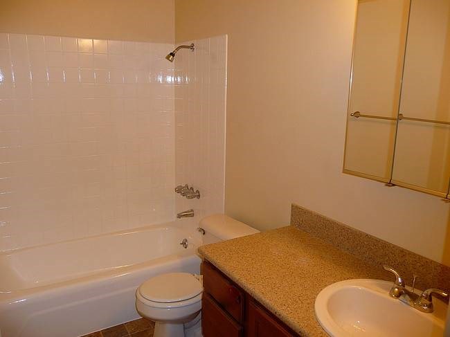 A white toilet sits next to a sink in a bathroom.