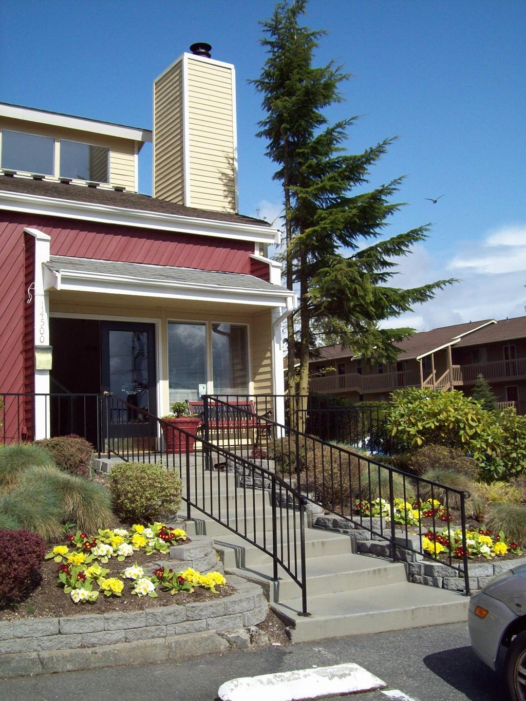 A house with a red front and a black railing.