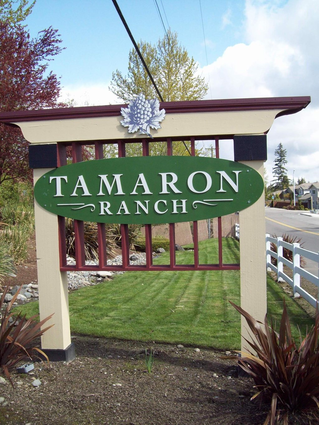 A sign that says Tamaron Ranch in front of a fence.