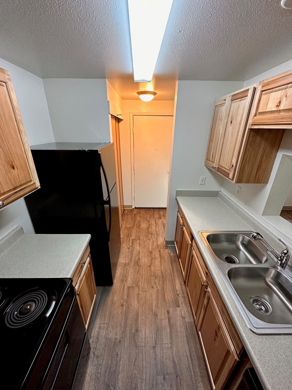 A kitchen with wooden cabinets and a black stove top oven.