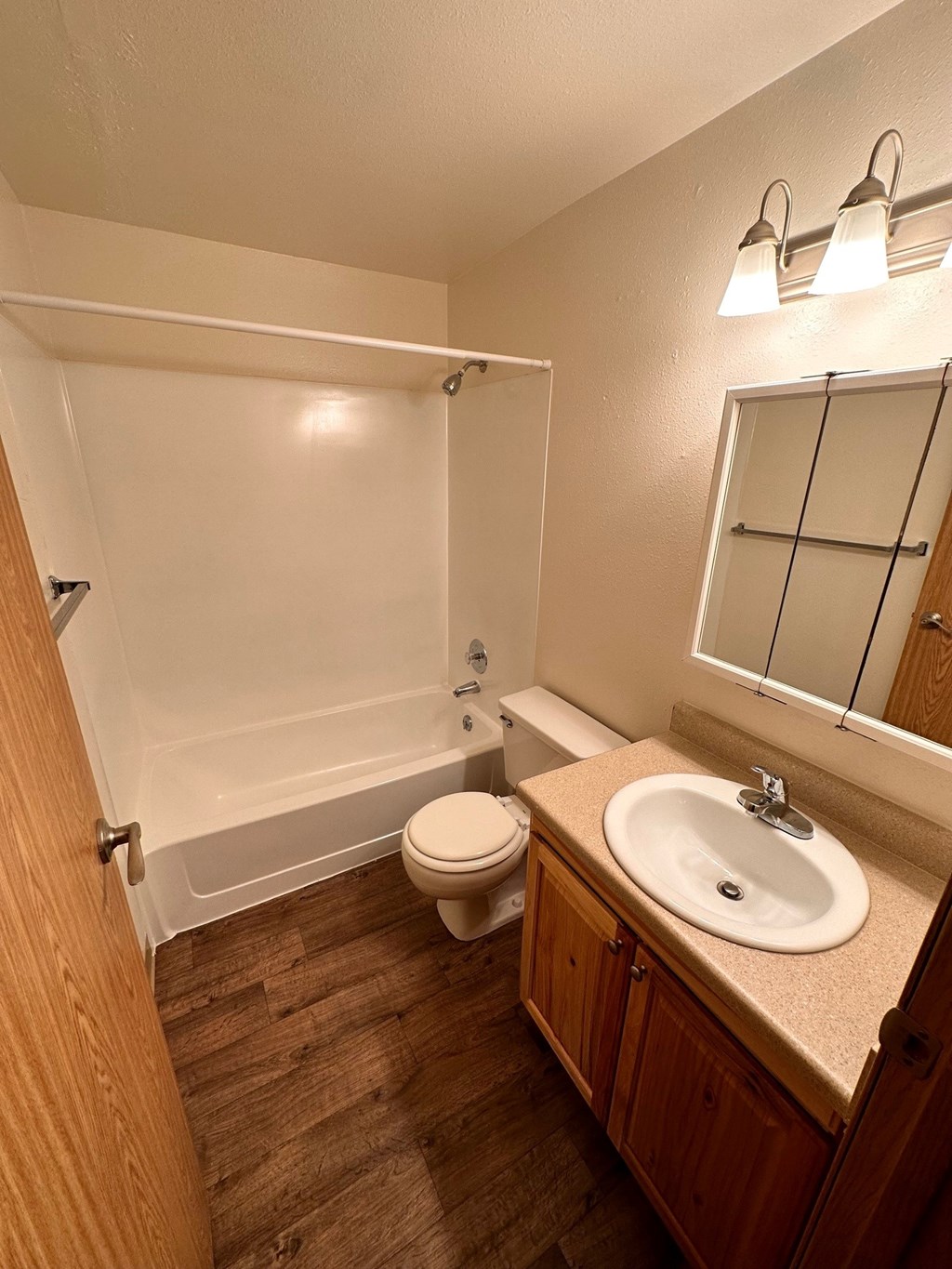 A small bathroom with a toilet, sink and bathtub.
