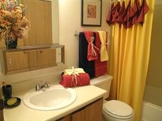 A bathroom with a toilet, sink, and yellow shower curtain.