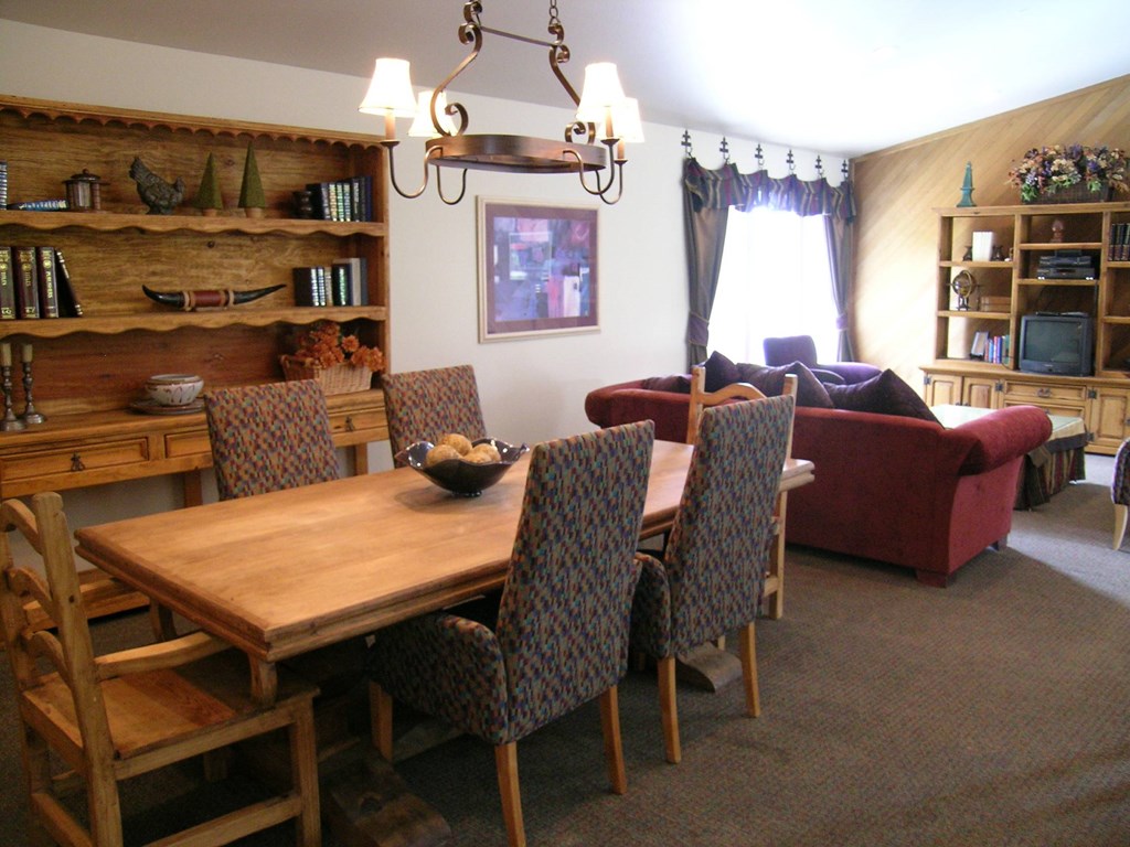 A dining room with a wooden table and chairs.