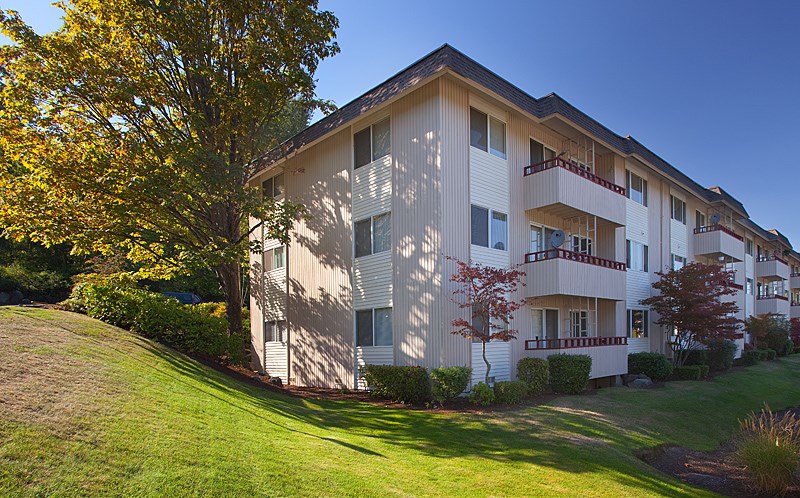 A large apartment building with a tree in front of it.