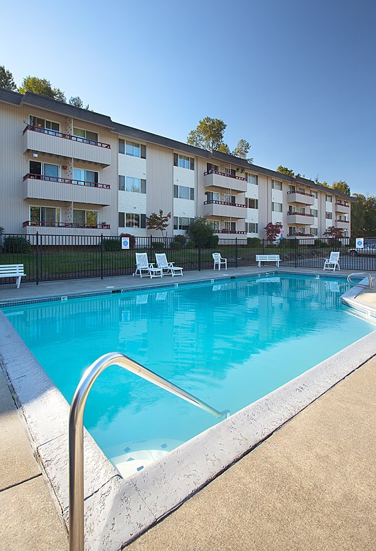 A swimming pool in front of apartment buildings.