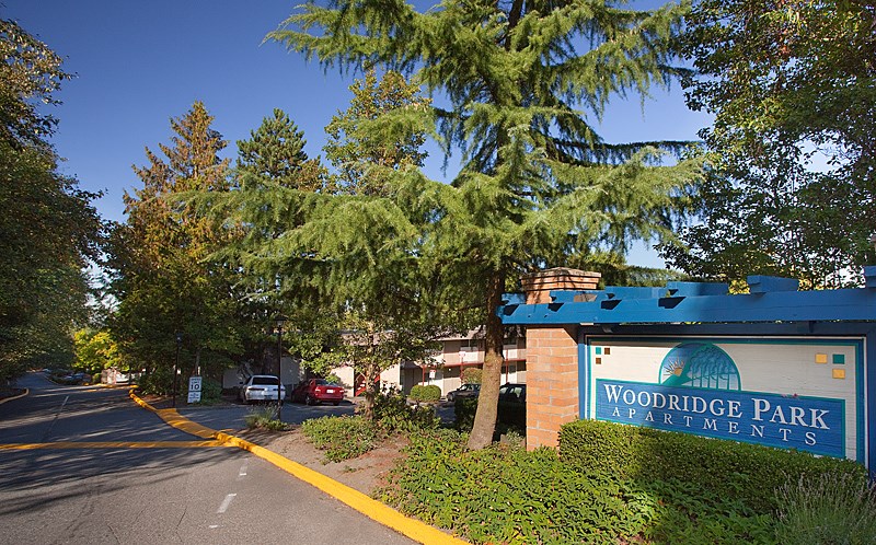 A sign for Woodridge Park Apartments is on the side of a street.