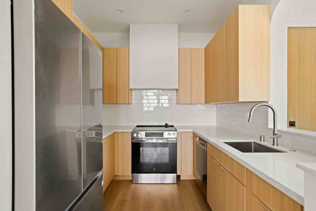 A modern kitchen with wooden cabinets and stainless steel appliances.