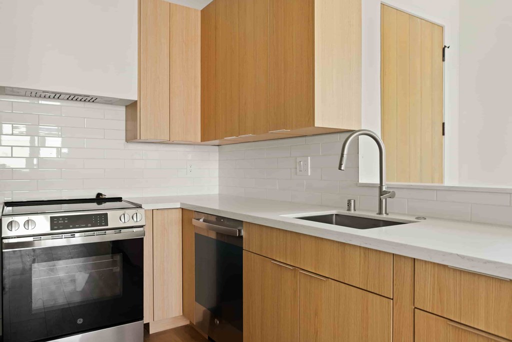 A kitchen with wooden cabinets and a black oven.