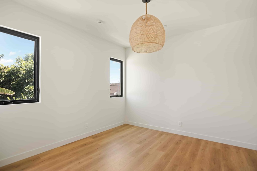 A room with a wooden floor and a hanging light fixture.