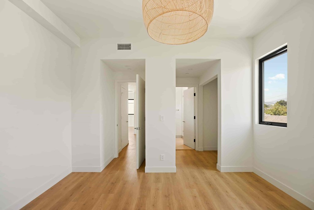 A long hallway with a light hanging from the ceiling.