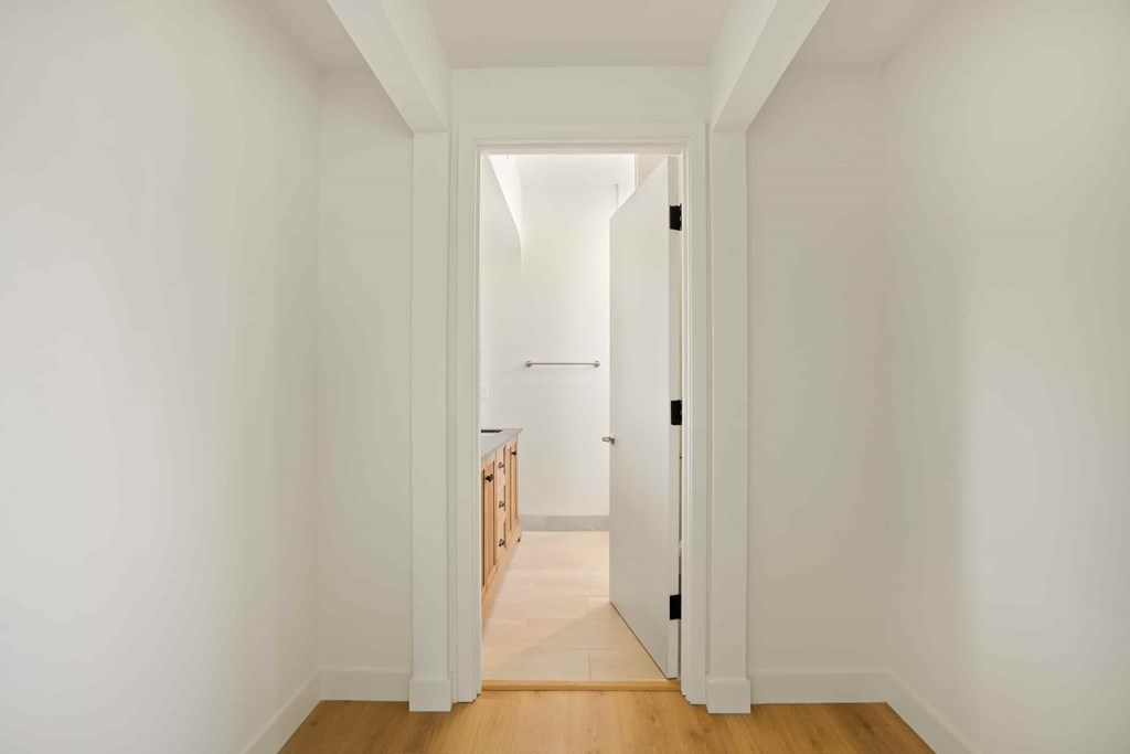 A hallway with a white door leading to another room.