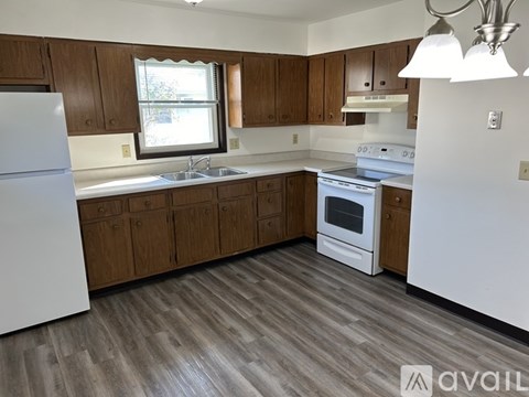 A kitchen with wooden cabinets and a white refrigerator.