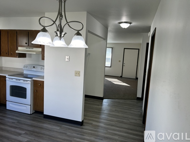 A modern kitchen with a white refrigerator and wooden cabinets.