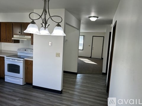 A modern kitchen with a white refrigerator and wooden cabinets.