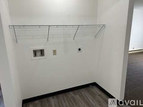Empty room with a shelf and two electrical outlets.